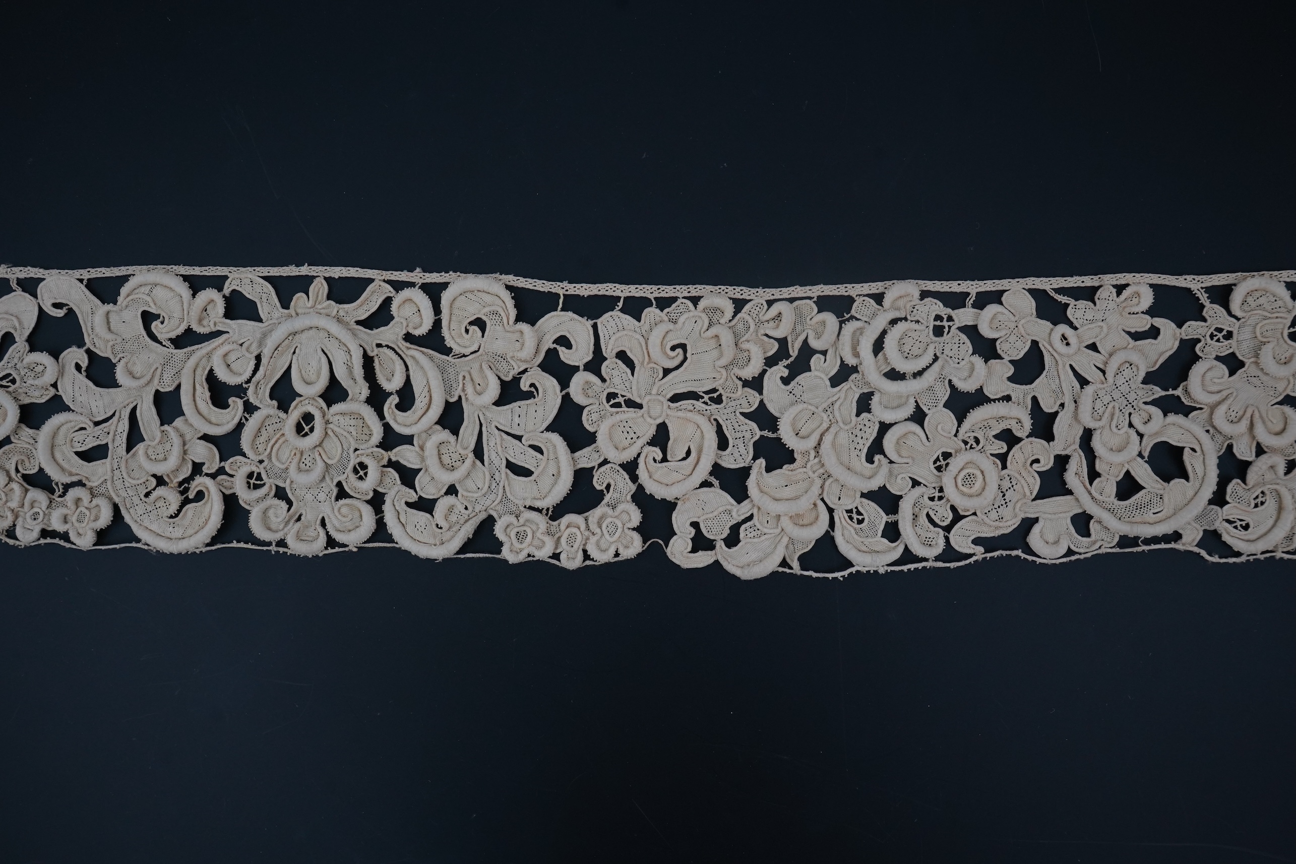 A length of 1660-1670 Italian Venetian Gros Point needle lace, this heavy needle lace was made with a wide cordonnet padded with wool, using close buttonhole stitch, to create large scrolling patterns in heavy relief, li